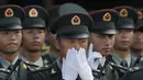 Seorang tentara mengusap wajahnya saat mengikuti upacara peringatan 20 tahun serah terima Hong Kong dari pemerintah Inggris ke China, di Hong Kong, Jumat (30/6). (AP Photo)