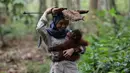 Staf bermain dengan salah satu orangutan yatim piatu di Sekolah Hutan Orangutan yang baru dibuka di Kalimantan Timur, 22 Mei 2018. Sebagai siswa angkatan pertama adalah delapan orangutan Kalimantan Timur usia 11 bulan hingga 9 tahun. (HO/FOUR PAWS/AFP)