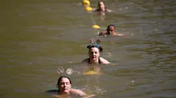 Peserta berenang di bendungan selama lomba lari Strongman Run di kota Paarl, Afrika Selatan, 13 Oktober 2018. Karena peserta yang semakin bertambah, Strongman Run kini diadakan beberapa kali setahun di berbagai negara di Eropa. (RODGER BOSCH/AFP)