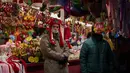 Pedagang menunggu pelanggan di pasar Natal di alun-alun Walikota di pusat kota Madrid, Spanyol (8/12/2021). PM Spanyol mendesak warga untuk "tetap berhati-hati" tentang COVID-19 selama liburan perayaan Natal karena salah satu rumah sakit Spanyol diduga menginfeksi 68 orang. (AP Photo/Manu Fernandez)