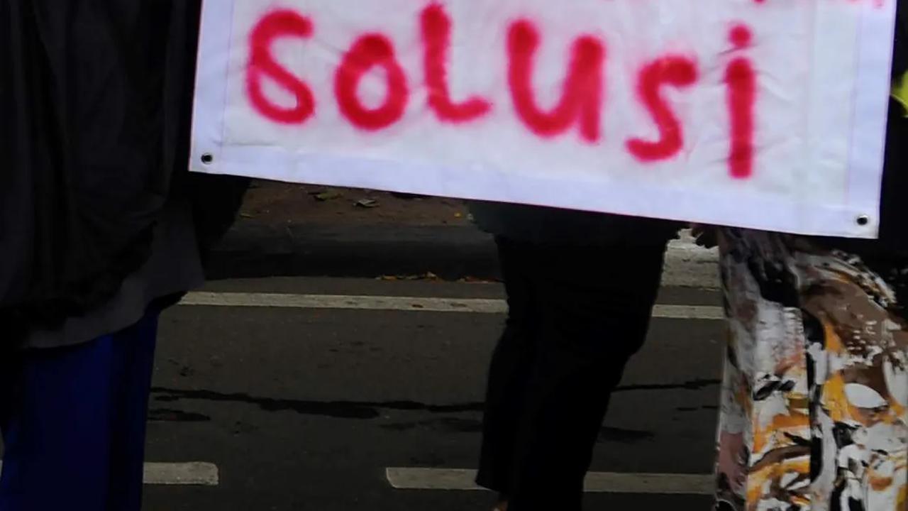 Demonstran ibu-ibu menunjukkan poster bertuliskan "Penggusuran Paksa Bukan Solusi" saat beraksi.