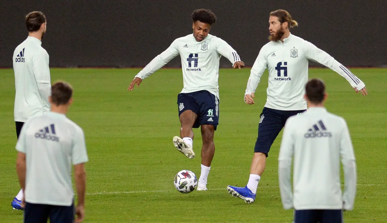 Gelandang Spanyol Adama Traore (tengah) dan bek Spanyol Sergio Ramos (kanan) mengikuti sesi latihan di stadion La Cartuja di Seville (17/11/2020). Pemenang laga antara Spanyol vs Jerman dipastikan menjadi pimpinan klasemen Grup A4. (AFP/Cristina Quicler)