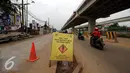 Sebuah papan peringatan terpasang di tengah tengah ruas jalan inspeksi Kalimalang, Jakarta, Selasa (14/6/2016). Jelang arus mudik Lebaran 2016, sebagian ruas jalan inspeksi Kalimalang masihterlihat rusak dan berlubang. (Liputan6.com/Helmi Fithriansyah)