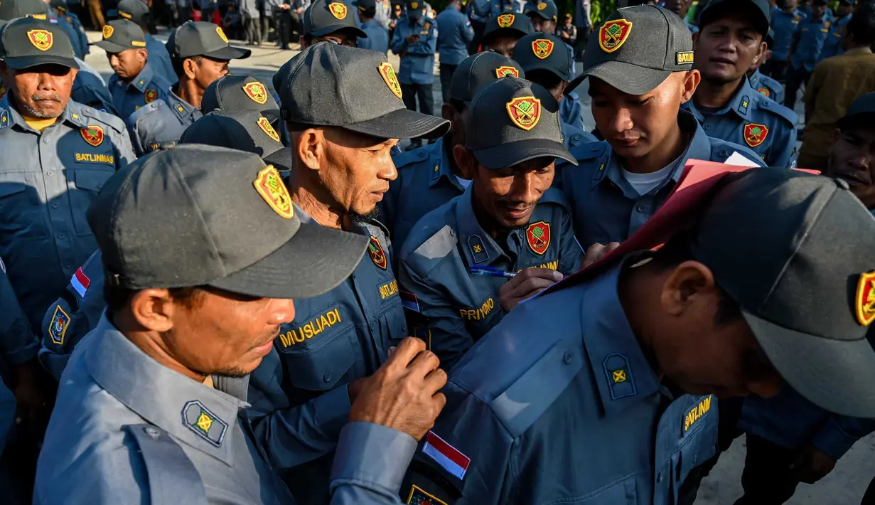 Anggota satuan perlindungan keamanan lokal (LINMAS) mengambil bagian dalam apel pengamanan pemilu di Banda Aceh pada 8 Februari 2024. (CHAIDEER MAHYUDDIN/AFP)