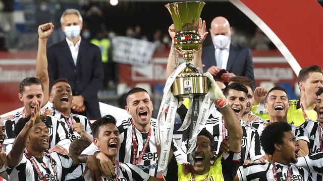 Kiper dan kapten Juventus, Gianluigi Buffon (tengah) mengangkat trofi Coppa Italia 2020/2021 di tengah-tengah rekannya usai mengalahkan Atalanta 2-1 dalam laga final di Mapei Stadium, Rabu (19/5/2021). (AP/Antonio Calanni)