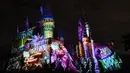 Cahaya warna-warni menghiasi kastil Dunia Harry Potter dihiasi cahaya biru di Universal Studios Hollywood, Universal City (16/11). Pertunjukan ini bertemakan 'The Magic of Christmas at Hogwarts Castle'. (AFP Photo/Chris Delmas)