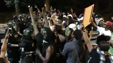 Unjuk rasa memprotes penembakan pria kulit hitam di Charlotte berujung ricuh, North Carolina, AS, Selasa (20/9). Massa terlibat saling dorong dengan polisi yang berjaga. (REUTERS/Adam Rhew)