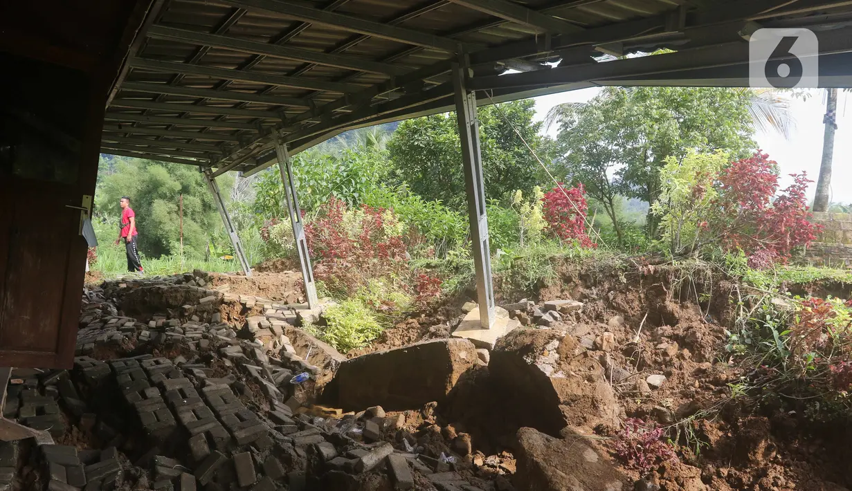 Warga melihat rumah yang rusak akibat pergeseran tanah di kawasan Bojong Koneng, Babakan Madang, Kabupaten Bogor, Jawa Barat, Jumat (16/9/2022). Badan Penanggulangan Bencana Daerah (BPBD) setempat mencatat 18 unit rumah mengalami kerusakan, dan pergeseran tanah itu menyebabkan retakan-retakan di tanah, dinding, plafon dan lantai rumah warga serta akses jalan sudah tidak bisa dilewati oleh kendaraan roda dua dan roda empat. (Liputan6.com/Herman Zakharia)