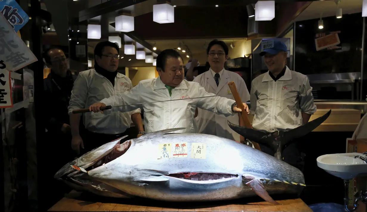 Kiyoshi Kimura usai memotong tuna sirip biru dengan berat 200 kg di Tsukiji, Tokyo, Jepang, Selasa (5/1). Tuna sirip biru yang berhasil direbut Kimura menjadi yang terberat dan termahal pada lelang ikan pertama 2016. (REUTERS/Toru Hanai)