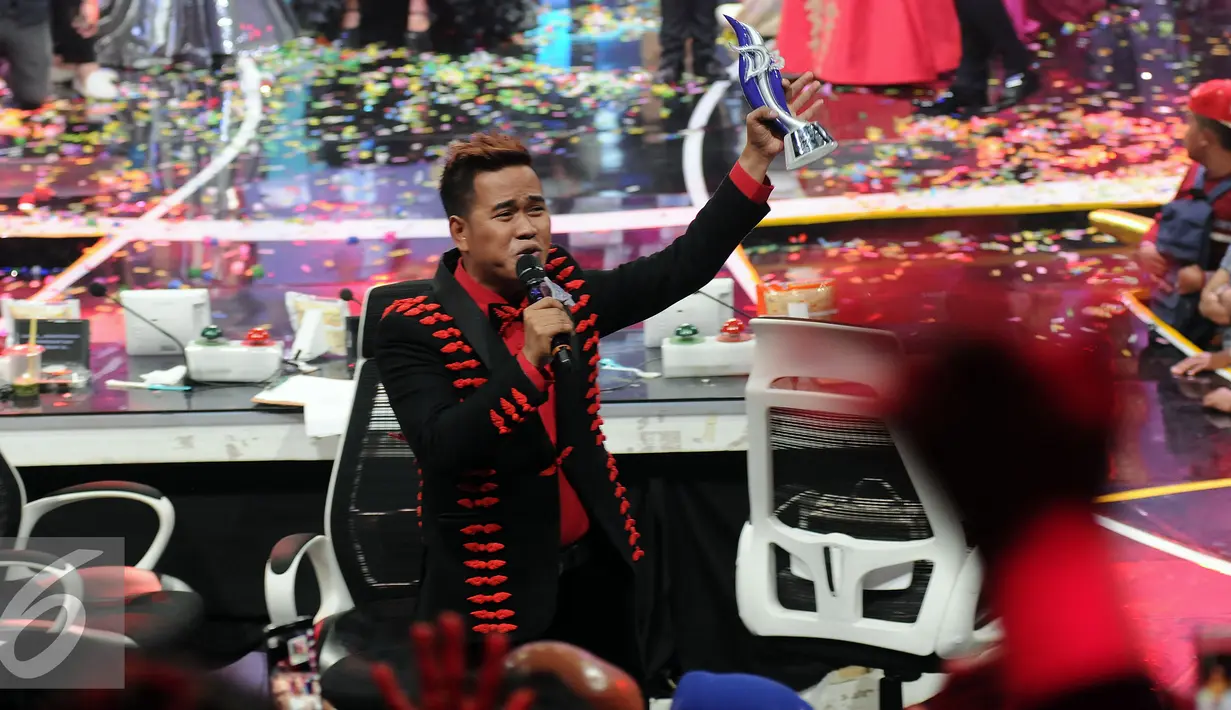 Finalis D Academy 3, Ical mengangkat piala kemenangan usai mengalahkan Weni di Panggung Kemenangan di Studio 5 Indosiar, Jakarta, Sabtu (28/5). Ical unggul pengumpulan polling sms 54.8% dari finalis asal Pontianak, Weni. (Liputan6.com/Helmi Fithriansyah)