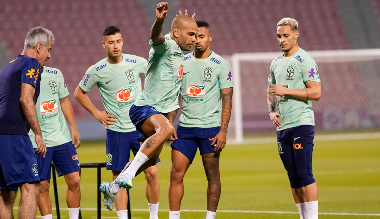 Pemain Brasil Dani Alves (tengah) dan rekan satu timnya berolahraga saat sesi latihan di Stadion Grand Hamad, Doha, Qatar, 29 November 2022. Brasil akan menghadapi Kamerun dalam pertandingan sepak bola Grup G Piala Dunia 2022 pada 2 Desember. (AP Photo/Andre Penner)