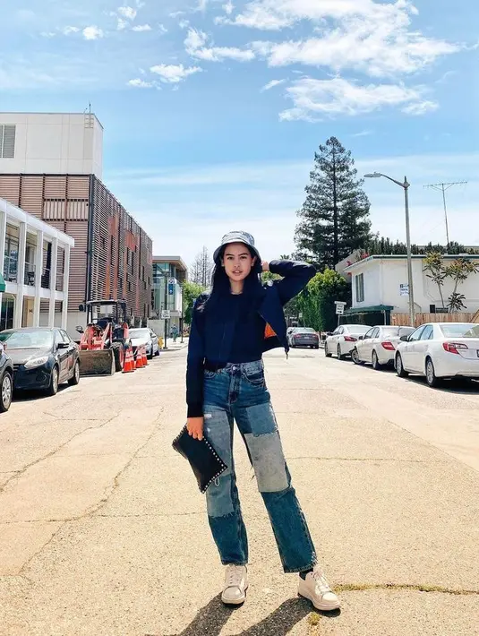 OOTD Maudy Ayunda berikut ini bisa kamu tiru untuk hangout. Padukan crop bomber jacket dengan high waist jeans. Sebagai pemanis, kenakan aksesoris berupa bucket hat. (Instagram/maudyayunda).