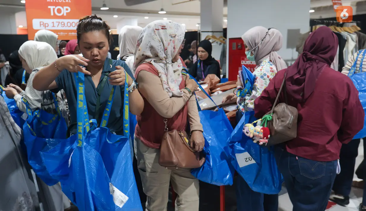 Seorang jastiper memeriksa produk pakaian sebelum membelinya dalam sesi berburu diskon Imperfect Sale 2026 di Blok M Square, Jakarta, Jumat (30/10/2026). Ketelitian diperlukan agar barang yang dipilih sesuai dengan daftar pesanan pelanggan. (KLY/Budy Santoso)