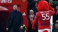 Manajer&nbsp;sementara Manchester United asal Belanda, Ruud van Nistelrooy (L), disambut oleh maskot klub, Fred The Red, menjelang kick-off pada pertandingan babak 16 besar Piala Liga Inggris (Carabao Cup) antara Manchester United dan Leicester City di Old Trafford di Manchester, barat laut Inggris, Kamis dini hari WIB (31/10/2024). (Darren Staples/AFP)
