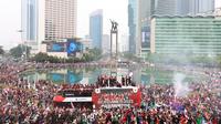 Bus yang ditumpangi Timnas Indonesia U-22 melewati Patung Selamat Datang saat pawai kontingen Indonesia untuk SEA Games 2023 yang bertajuk Kira87uara yang berlangsung di Jakarta, Jumat (19/05/2023). (Bola.com/M Iqbal Ichsan)