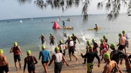 Para peserta berebut masuk air saat start Rhino Cross Triathlon pada Festival Pesona Tanjung Lesung 2017 di Tanjung Lesung, Banten (24/9/2017). Total jarak tempuh Rhino Cross Triathlon 38 km. (Bola.com/Nicklas Hanoatubun)