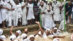 Sejumlah pengikuti Voodoo Haiti melakukan ritual saat mandi di kolam suci selama upacara voodoo di Souvenance, Haiti (4/1). Mereka datang ke Souvenance pada akhir pekan Paskah untuk memberikan penghormatan kepada para roh. (AFP/Hector Retamal)