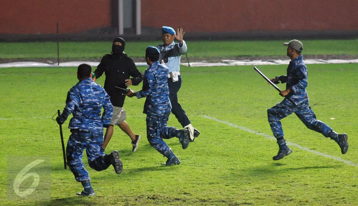 Petugas keamanan mengejar suporter tim Bajul Ijo yang masuk lapangan saat laga penyisihan Dirgantara Cup 2017 antara Persebaya melawan Cilegon Utd di Stadion Maguwoharjo, Sleman, Sabtu (4/3). Persebaya kalah 1-2. (Liputan6.com/Helmi Fithriansyah)