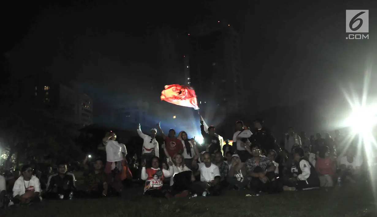 Para pendukung Capres dan Cawapres nomor urut 01 dan 02 saat nonton bareng Debat Perdana Pilpres di kawasan Gedung Bidakara, Jakarta, Kamis (17/1). Mereka menonton lesehan dengan layar tancap yang disediakan warga sekitar. (merdeka.com/Iqbal S Nugroho)