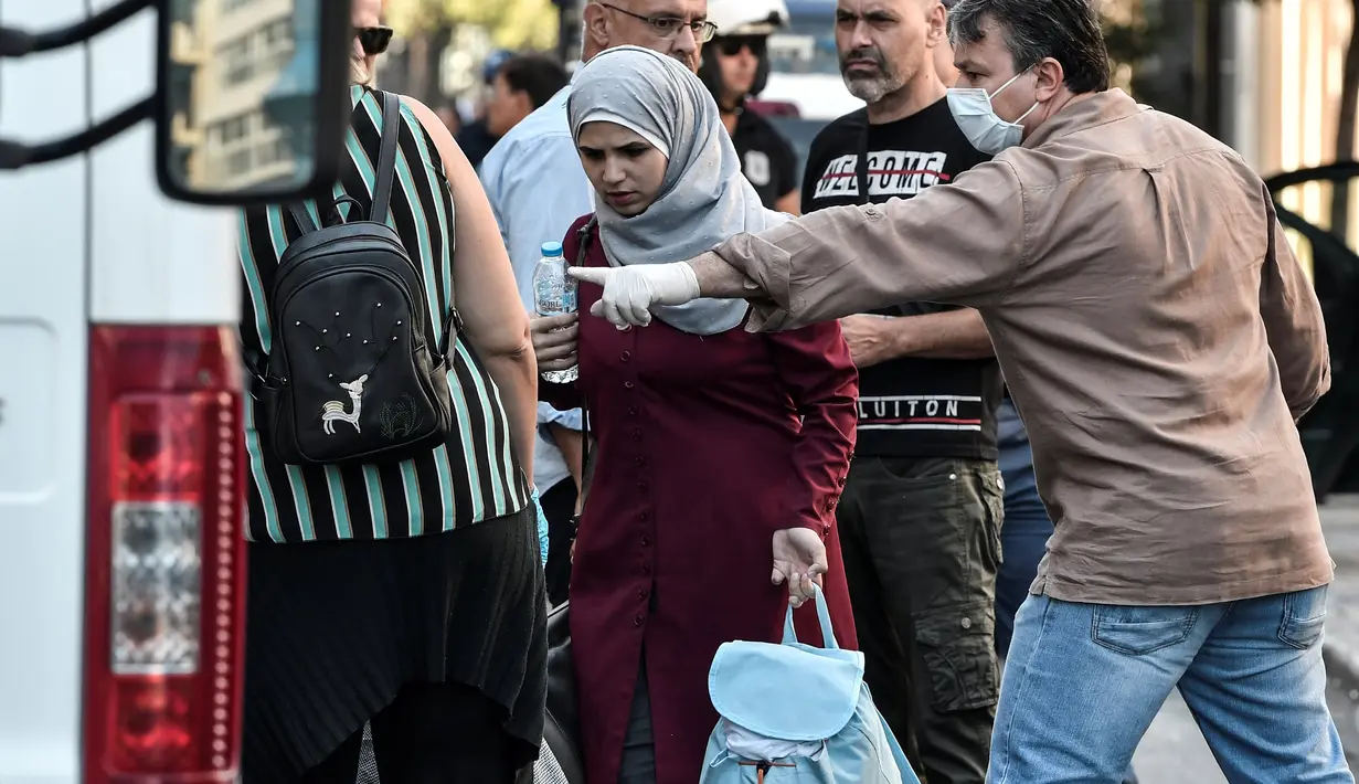 Seorang imigran wanita bersiap naik bus selama operasi polisi di pusat Athena, Yunani (19/9/2019). Pembersihan para imigran di pusat kota tersebut digerakkan oleh pemerintah konservatif yang baru. (AFP Photo/Louisa Gouliamaki)
