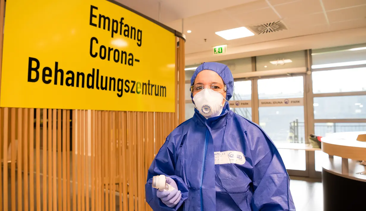 Seorang staf medis mengenakan pakaian APD berdiri di dalam pusat pengujian COVID-19 di stadion milik Borussia Dortmund di (4/4/2020). Kamar-kamar di tribun utara Stadion Westfalen dipersiapkan untuk menampung orang-orang yang diduga terinfeksi COVID-19.  (Xinhua/Borussia Dortmund/Alexandre Simoes)