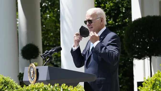 Presiden Amerika Serikat Joe Biden melepas maskernya saat mulai berbicara di Taman Mawar Gedung Putih, Washington, Amerika Serikat, 27 Juli 2022. Biden harus diisolasi di kediamannya di Gedung Putih sejak positif COVID-19 pada Kamis lalu. (AP Photo/Susan Walsh)