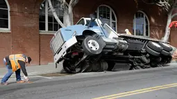 Petugas membuat tanda di sekitar lokasi truk yang terjebak di sebuah saluran pembuangan di San Francisco, AS, Jumat (5/5). (AP Photo / Jeff Chiu)