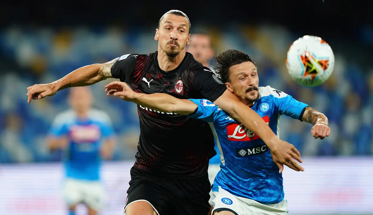 Penyerang AC Milan, Zlatan Ibrahimovic (kiri) berebut bola dengan pemain Napoli, Mario Rui  pada pertandingan lanjutan Liga Serie A Italia di Stadion San Paolo di Naples, Italia, Minggu, (12/7/2020). AC Milan bermain imbang 2-2 atas Napoli. (Spada/LaPresse via AP)