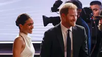 Meghan Markle mencuri perhatian dengan gaun halter neck yang mirip dipakai saat pernikahan dengan Pangeran Harry. (Dok: Frazer Harrison/AFP)