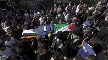 Militan Palestina membawa jenazah wartawan Al Jazeera Shireen Abu Akleh ke kamar mayat rumah sakit di Kota Jenin, Tepi Barat, Rabu (11/5/2022). Menurut Kementerian Kesehatan Palestina, Shireen Abu Akleh tewas ditembak saat meliput serangan Israel di Kota Jenin. (AP Photo/Majdi Mohammed)