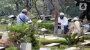 Peziarah membaca doa di salah satu makam di Tempat Pemakaman Umum Karet Bivak, Jakarta, Sabtu (18/4/2020). Selama masa PSBB, peziarah yang memasuki kawasan TPU dibatasi dan diwajibkan menggunakan masker sebagai langkah pencegahan penyebaran virus Covid-19. (Liputan6.com/Helmi Fithriansyah)