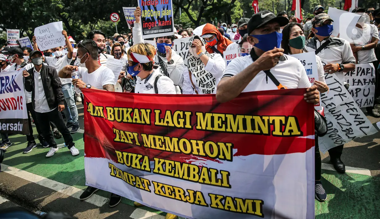 Massa yang tergabung dalam Aliansi Karyawan Hiburan dan Pengusaha Hiburan membentangkan spanduk saat menggelar aksi di depan Balai Kota DKI Jakarta, Selasa (21/7/2020). Mereka meminta Gubernur Anies Baswedan membuka usaha hiburan yang ditutup akibat pandemi COVID-19. (Liputan6.com/Faizal Fanani)