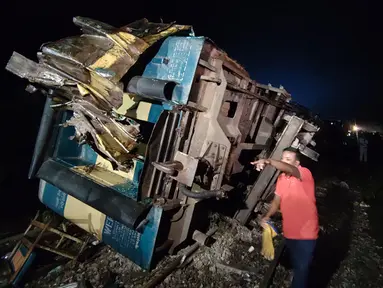 Warga sekitar membantu proses penyelamatan kecelakaan kereta di Bhairab, Distrik Kishoreganj, Bangladesh, Senin (23/10/2023). Kecelakaan melibatkan kereta kargo dan kereta penumpang. (AP Photo/Mahmud Hossain Opu)