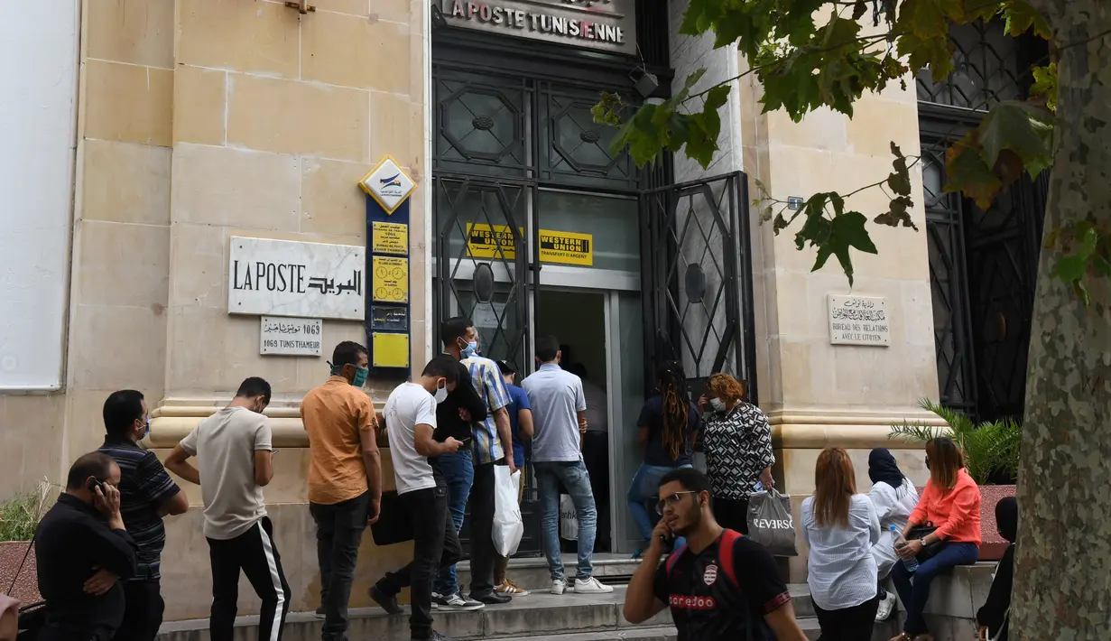 Orang-orang yang mengenakan masker mengantre untuk memasuki kantor pos di Tunis, Tunisia, pada 5 Oktober 2020. Perdana Menteri Tunisia Hichem Mechichi pada 3 Oktober mengumumkan serangkaian langkah untuk membatasi penyebaran cepat COVID-19 di negara tersebut. (Xinhua/Adel Ezzine)