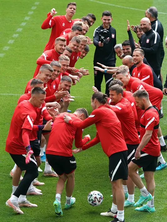 Para pemain Polandia merayakan ulang tahun rekannya Mateusz Klich selama sesi latihan mereka di Arena Gdansk di Gdansk, Minggu (13/6/2021). Pertandingan pembuka Grup E Euro 2020 akan mempertemukan timnas Polandia vs timnas Slovakia di Stadion Krestovsky pada Senin (14/6) WIB. (JANEK SKARZYNSKI/AFP)