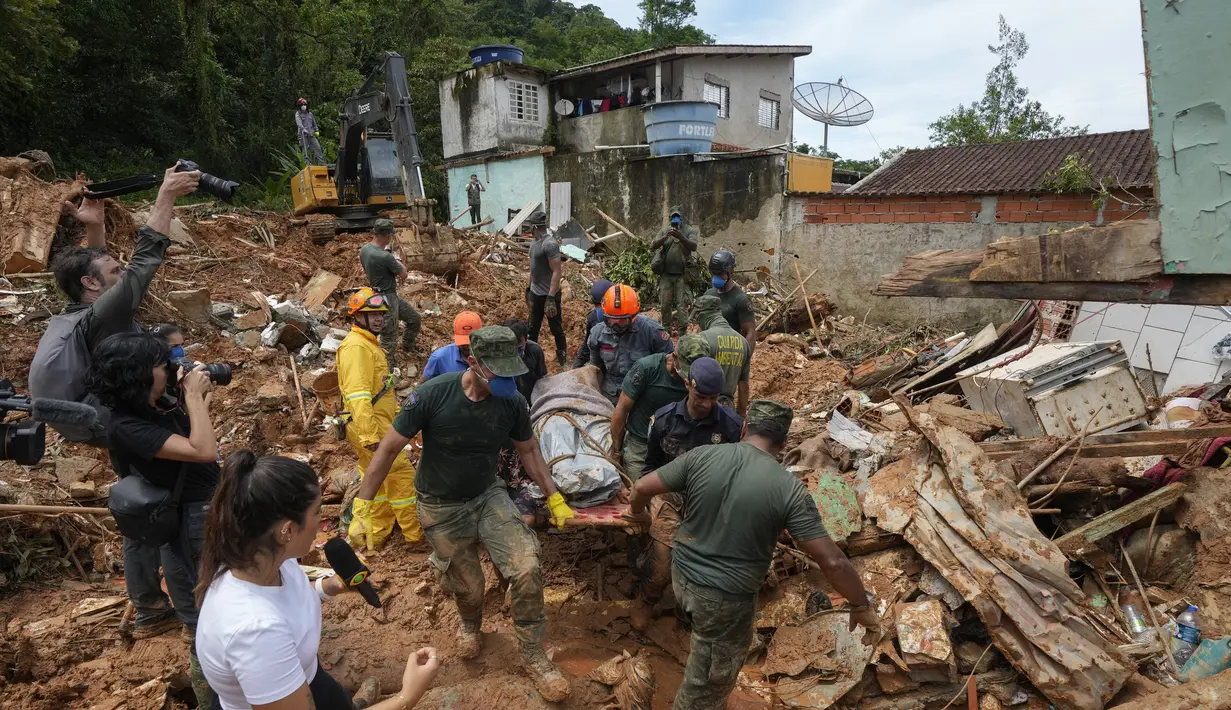 Petugas penyelamat dan relawan membawa jenazah korban longsor di dekat pantai Barra do Sahy setelah hujan lebat di kota pesisir Sao Sebastiao, Brasil, Rabu, 22 Februari 2023. Sekitar 1.730 orang telah mengungsi dan 1.810 kehilangan tempat tinggal, menurut pemerintah negara bagian Sao Paulo. (AP Photo/Andre Penner)