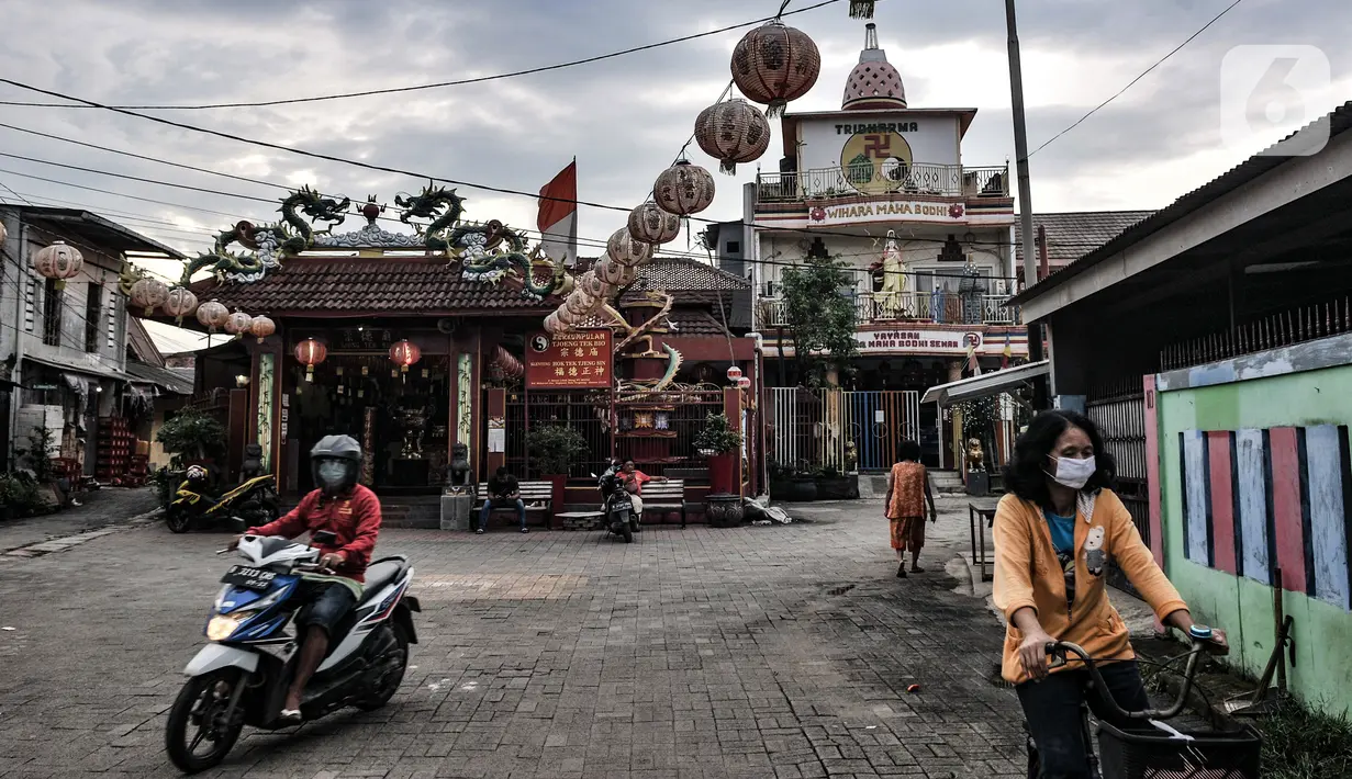 Warga melintas di depan Klenteng Tjong Tek Bio, Kampung Tehyan, Tangerang, Banten, Selasa (9/2/2021). Kehidupan masyarakat Cina Benteng di Tangerang diawali dari berlabuhnya nenek moyang mereka di Teluk Naga pada 1407 yang dipimpin oleh Chen Ci Lung. (merdeka.com/Iqbal S. Nugroho)