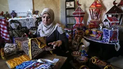 Hanan al-Madhoun (37) membuat lentera tradisional yang disebut "fanous" di rumahnya di Kota Gaza, menjelang bulan suci Ramadan dan di tengah pandemi virus corona, pada 1 April 2021. Warga biasanya memasang lentara sebagai dekorasi rumah untuk merayakan dimulainya Ramadan. (MAHMUD HAMS / AFP)