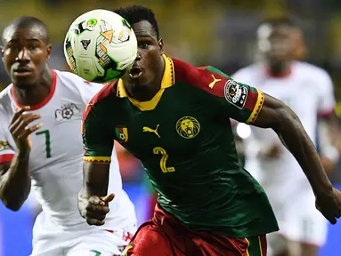 Bek Kamerun, Ernest Mabouka, berebut bola dengan gelandang Burkina Faso, Prejuce Nakoulma, pada laga Grup A Piala Afrika di Stade de l'Amitie Sino-Gabonaise, Gabon, Sabtu (14/1/2017). Kedua negara bermain imbang 1-1. (AFP/Gabriel Bouys)