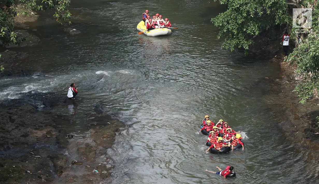 Tim pengibar bendera menaiki perahu karet menyusuri Sungai Ciliwung menuju Jembatan Panus, Depok, Kamis (17/8). Komunitas Ciliwung Depok menggelar upacara peringatan HUT Kemerdekaan RI di atas Jembatan Panus. (Liputan6.com/Herman Zakharia)