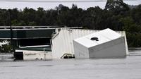 Sebuah kontainer mengapung saat air banjir yang naik membanjiri area komersial akibat hujan lebat di pinggiran barat daya Camden, Sydney, Australia, Selasa (8/3/2022). (Muhammad FAROOQ/AFP)