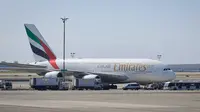 Mobil dan petugas kesehatan mengepung pesawat setelah penumpang Emirates Airline dilaporkan sakit di Bandara Kennedy New York, Rabu (5/9). Belum ada keterangan resmi tentang penyakit yang dikeluhkan penumpang serta awak pesawat itu. (AP/Bebeto Matthews)