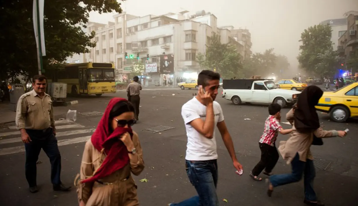 Sempat terjadi kepanikan, beberapa warga Iran terlihat berjalan di tengah-tengah debu pasir di Teheran, Iran, (2/6/2014). (AFP PHOTO/ISNA/Hamidreza Dastjerdi)