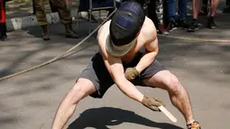 Seorang pemuda saat bertarung menggunakan pisau kayu dalam memperagakan keterampilan mereka di taman kota di Kiev, Ukraina (21/4). Para petarung pisau kayu ini tidak ikut dalam kompetisi apapun. (AP Photo / Efrem Lukatsky)