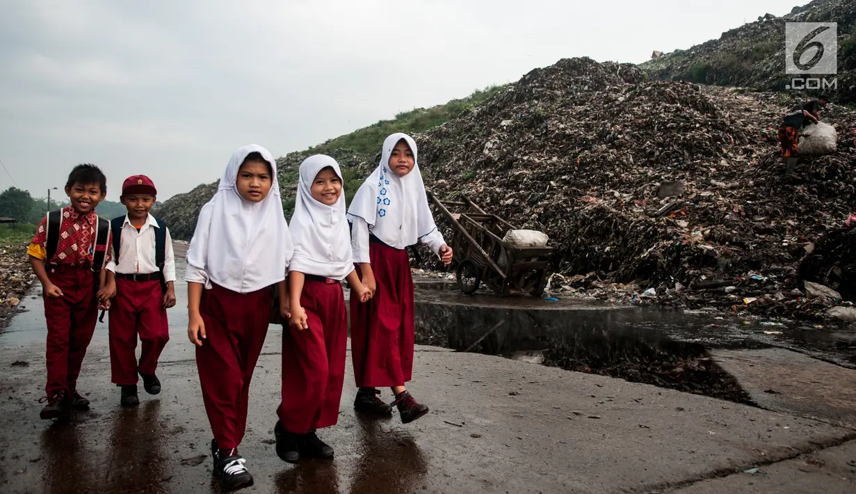 Sejumlah anak sekolah berjalan di samping tumpukan sampah di TPA Bantar Gebang, Kota Bekasi, Jawa Barat.  (Liputan6.com/Yoppy Renato)