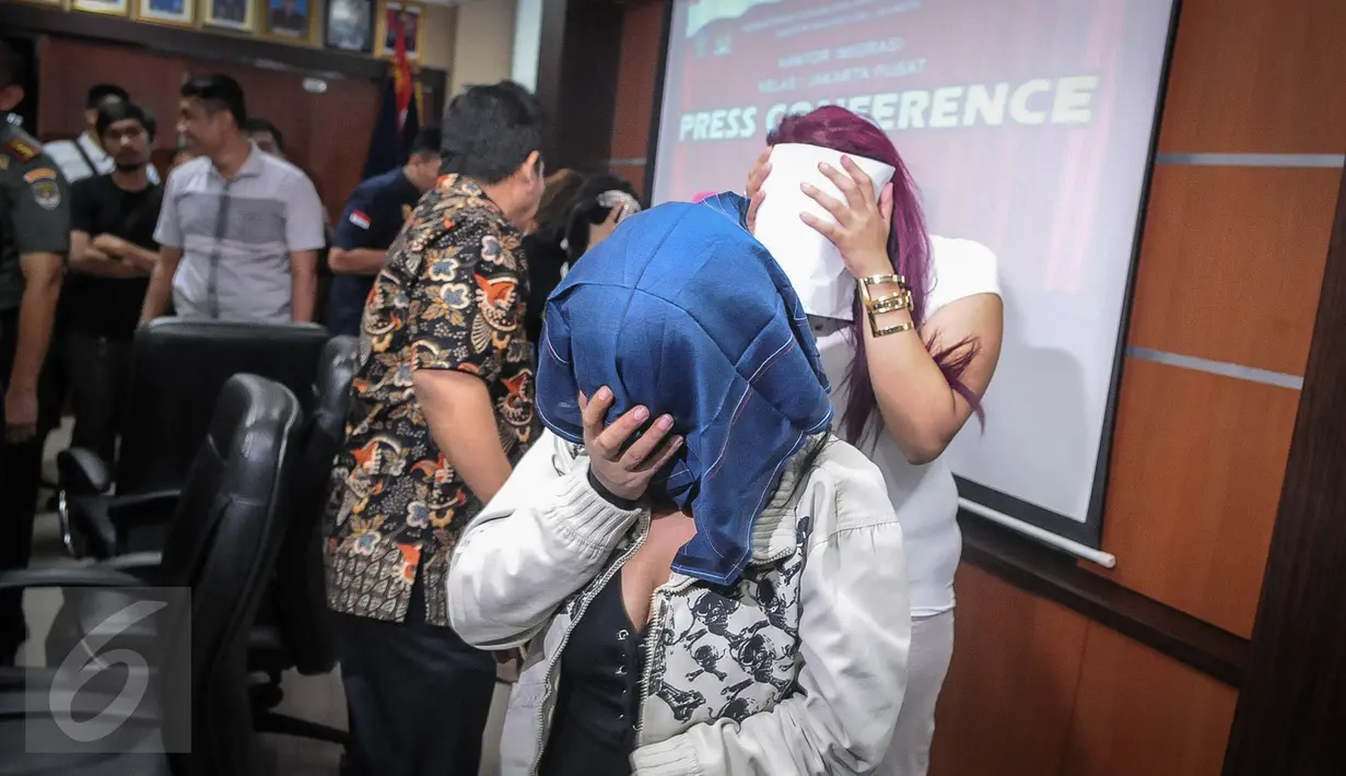 Petugas menggiring sejumlah wanita yang terjaring operasi usai rilis di Imigrasi Kelas I Jakarta Pusat, Jumat (21/10). 17 wanita asal Maroko berusia 20-29 tahun itu diciduk petugas imigrasi di sebuah diskotek kawasan Senayan. (Liputan6.com/Faizal Fanani)