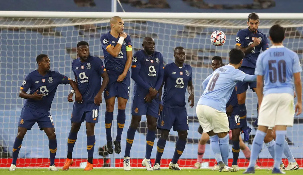 Gelandang Manchester City, Ilkay Gundogan, mencetak gol melalui tendangan bebas ke gawang FC Porto pada laga Liga Champions di Stadion  Etihad, Kamis (22/10/2020). City menang dengan skor 3-1. (Martin Rickett/Pool via AP)