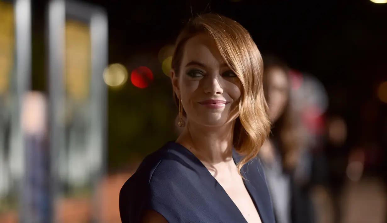 Emma Stone berpose saat menghadiri pemutaran perdana "Zombieland: Double Tap" di Teater Village Village di Los Angeles (10/10/2019). Emma Stone melengkapi penampilannya dengan sepasang anting rantai emas, cincin yang serasi, dan sepasang stiletto bertali emas. (AFP Photo/Alberto E. Rodriguez)