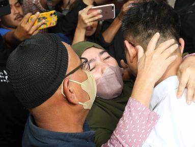 Terdakwa kasus dugaan perintangan penyidikan pada kasus pembunuhan Brigadir Yosua, Irfan Widyanto dipeluk oleh orang tuanya usai menjalani sidang putusan di Pengadilan Negeri Jakarta Selatan, Jumat (24/2/2023).  AKP Irfan Widyanto divonis 10 bulan penjara dan denda sebesar Rp10 Juta oleh Majelis Hakim Pengadilan Negeri Jakarta Selatan. (Liputan6.com/Herman Zakharia)