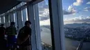 Pengunjung melihat pemandangan dari gedung pencakar langit Lotte World Tower 123 lantai di Seoul pada 22 September 2021. Lotte World Tower dioperasikan sebagai sebuah kompleks termasuk perkantoran, fasilitas residensial, hotel bintang 6, dan observatorium. (Anthony WALLACE / AFP)